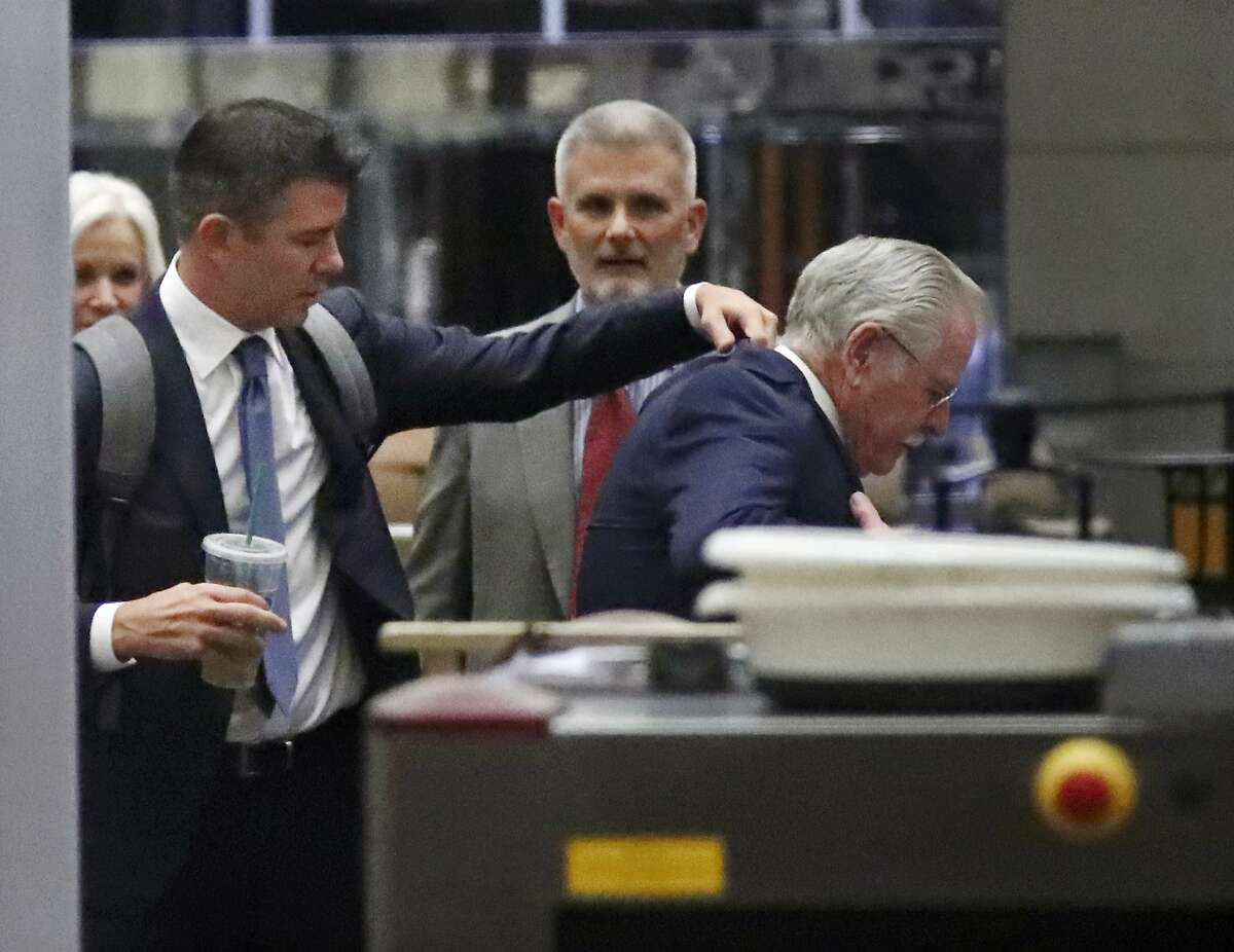 Former Uber CEO Travis Kalanick, left, adjusts the jacket of another man after passing through security at a federal courthouse on Wednesday, Feb. 7, 2018, in San Francisco. Kalanick took the witness stand ?Wednesday for a second day ?offering his initial response to allegations that he cooked up a scheme to steal self-driving car technology from Google. (AP Photo/Ben Margot)