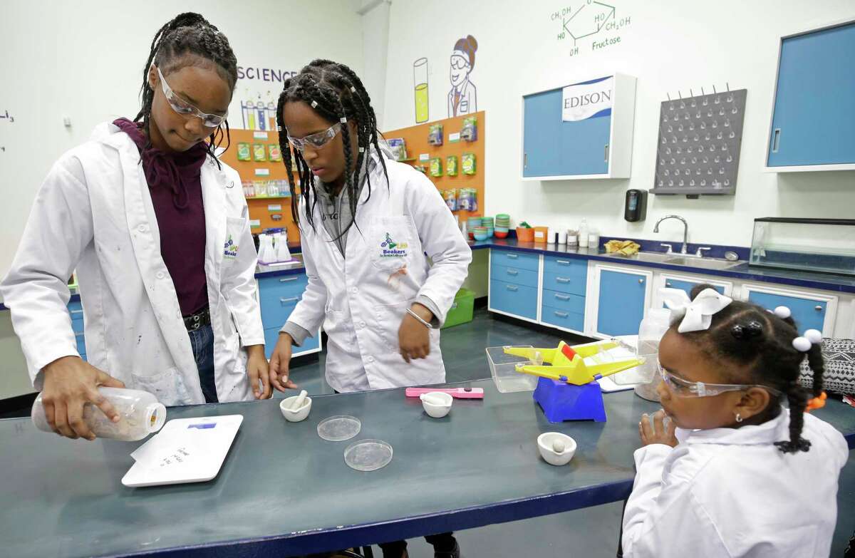 Kiyah Roberson, 13, left, and her sisters, Eryka Roberson, 12, center, and Jaira Ford, 6, right, work on an experiment at Little Beakers on Jan. 15, 2018, in Oak Ridge North. The experiment was to use a magnet to see the iron in cereal. ( Melissa Phillip / Houston Chronicle )