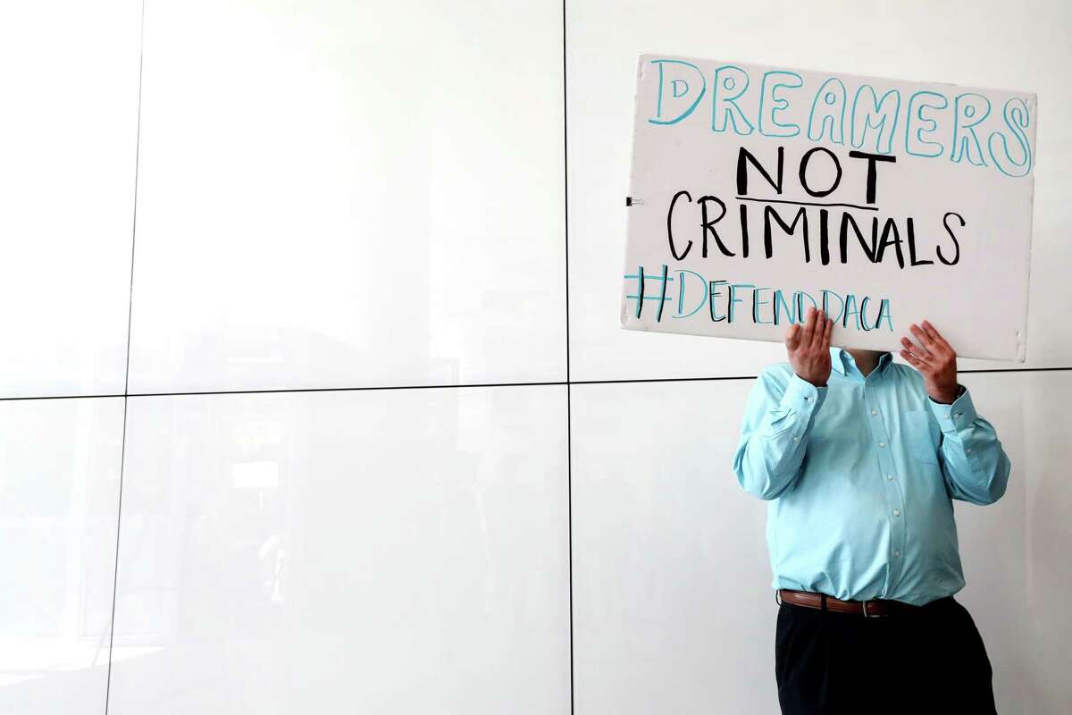 A man holds a sign during a press conference at the Mickey Leland Federal Building on Oct. 9, 2017, calling for action to help DACA recipients. ( Jon Shapley / Houston Chronicle )