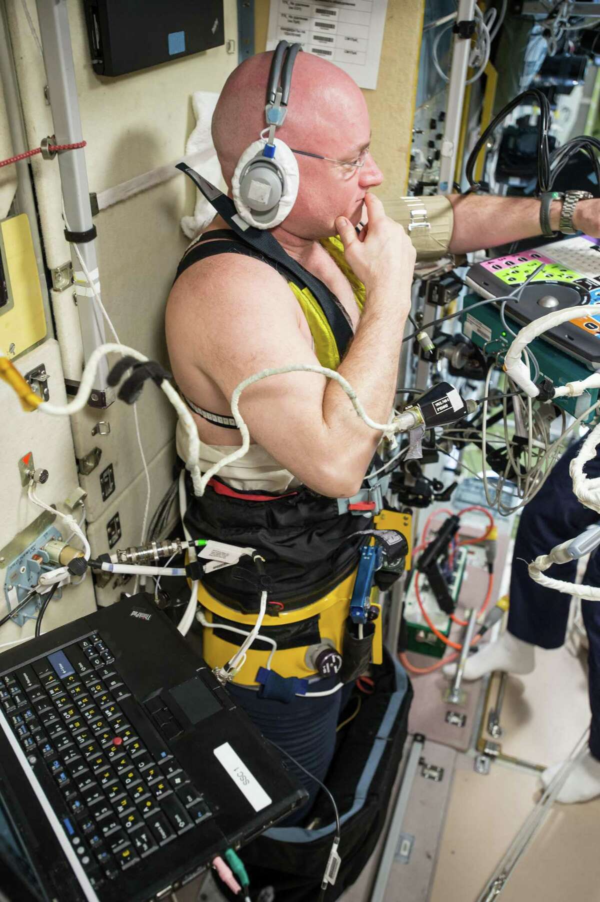 NASA astronaut Scott Kelly, wearing a headset and a Chibis Lower Body Negative Pressure Suit, undergoes ultrasound measurements.