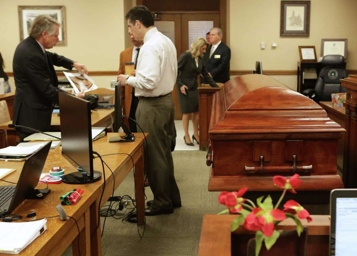 Robert “Dick” Tips and his wife Kristin Tips stand at the courtroom door in the 131st Civil District Courtroom, as lawyers prepare for the trial, next to a coffin they had brought in for Tip’s trial on Thursday, Feb. 8, 2018.