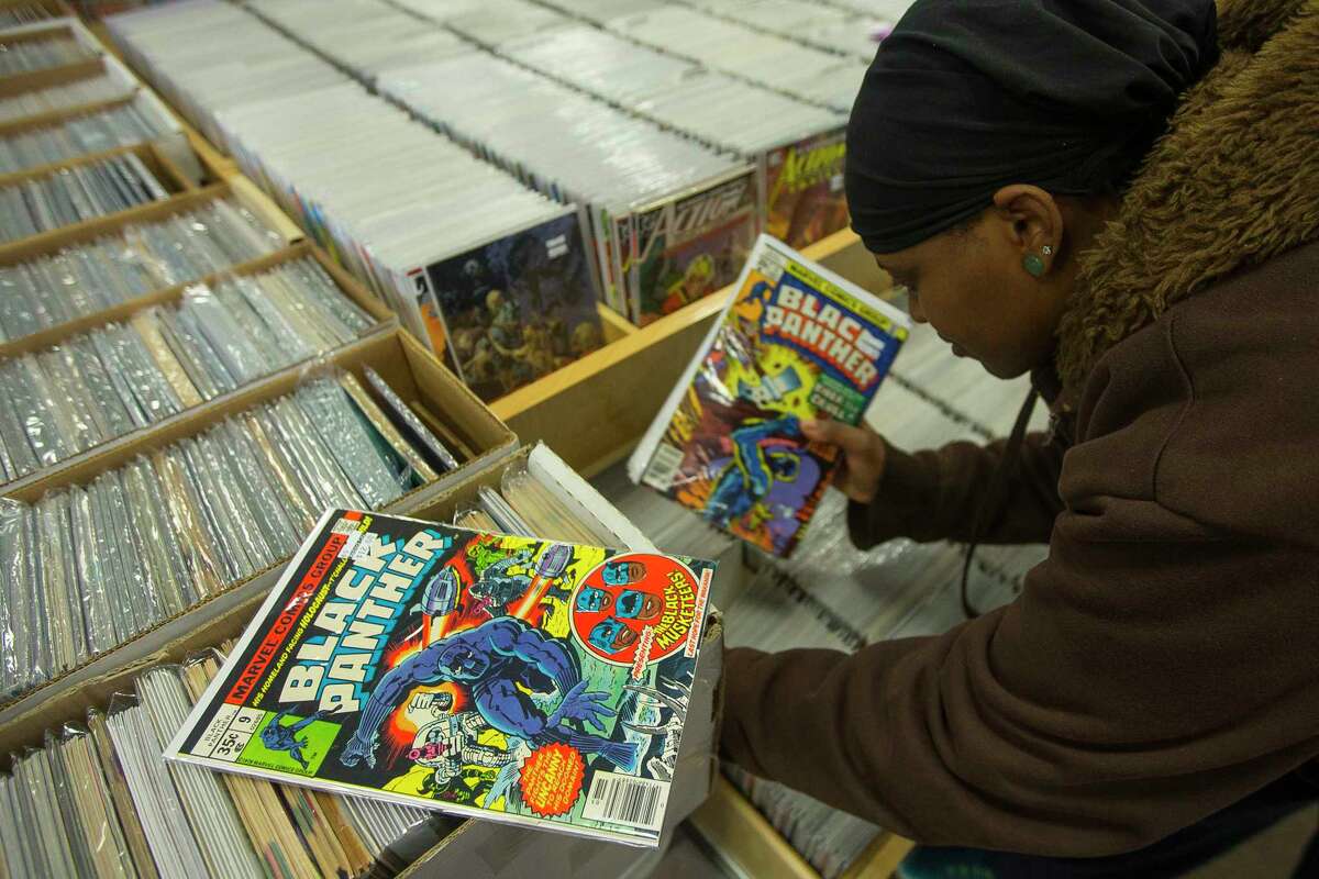 Bianca Lister searches for issues of the Black Panther comic book series at Bedrock City Comic Company, Thursday, Feb. 8, 2018, in Houston. She ended up buying a #9 from the original volume for a duplicate set of the original series she is putting together in her personal collection. Lister has been a fan of the series for a long time, and she is excited about the upcoming premiere of the movie. "I work, I go to school, and I'm still going to the midnight premiere," said Lister. One downside of the popularity of the upcoming movie is that Lister has seen the availability of the comics she collects go down and prices go up.