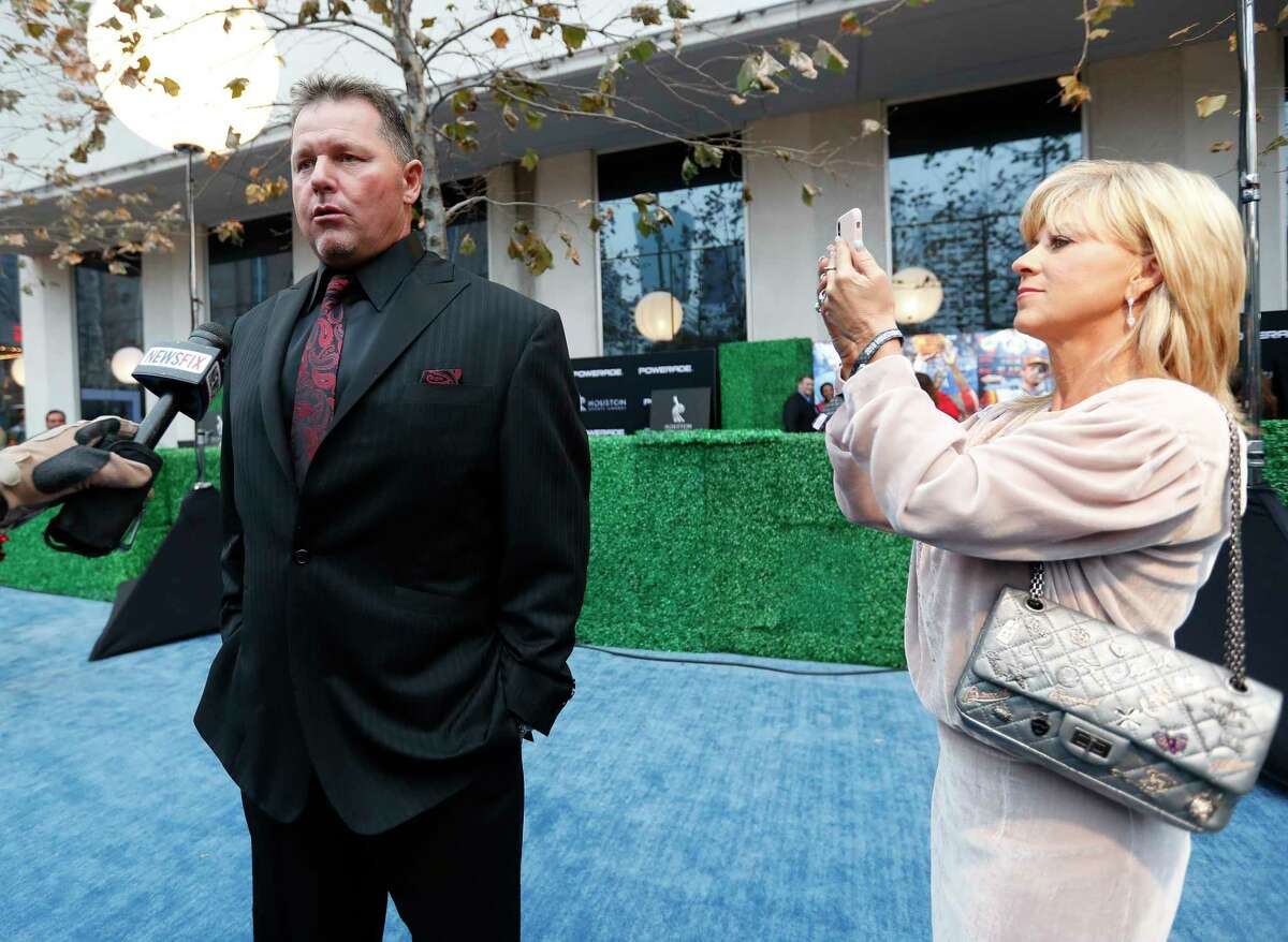 Debbie Clemens takes a photo of her husband Roger Clemens being interviewed on the blue carpet before the start of the Houston Sports Awards at the Hilton Americas, Thursday, Feb. 8, 2018, in Houston.