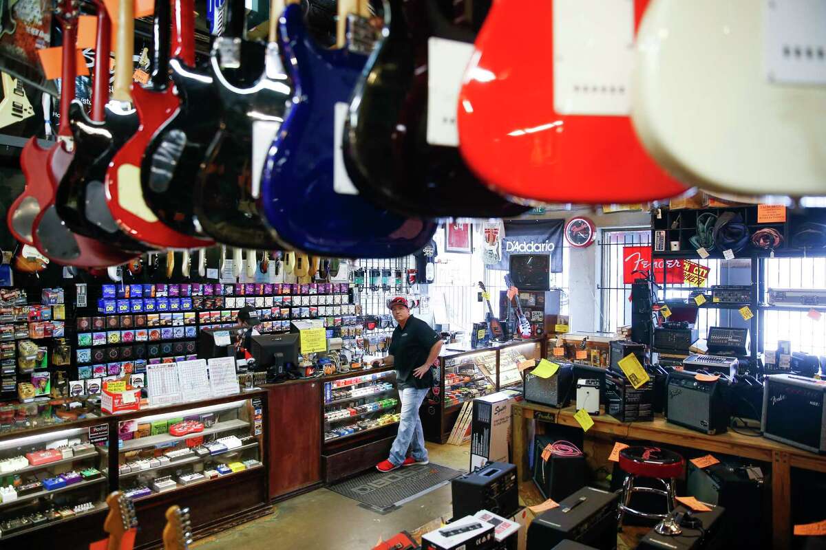 Customer Thomas Coffman surveys the Rockin' Robin Guitars store while checking out Thursday, Feb. 8, 2018 in Houston. After more than 45 years of being in business, owner Bart Wittrock is putting the store on the market in hopes of finding a new and energetic owner. (Michael Ciaglo / Houston Chronicle)