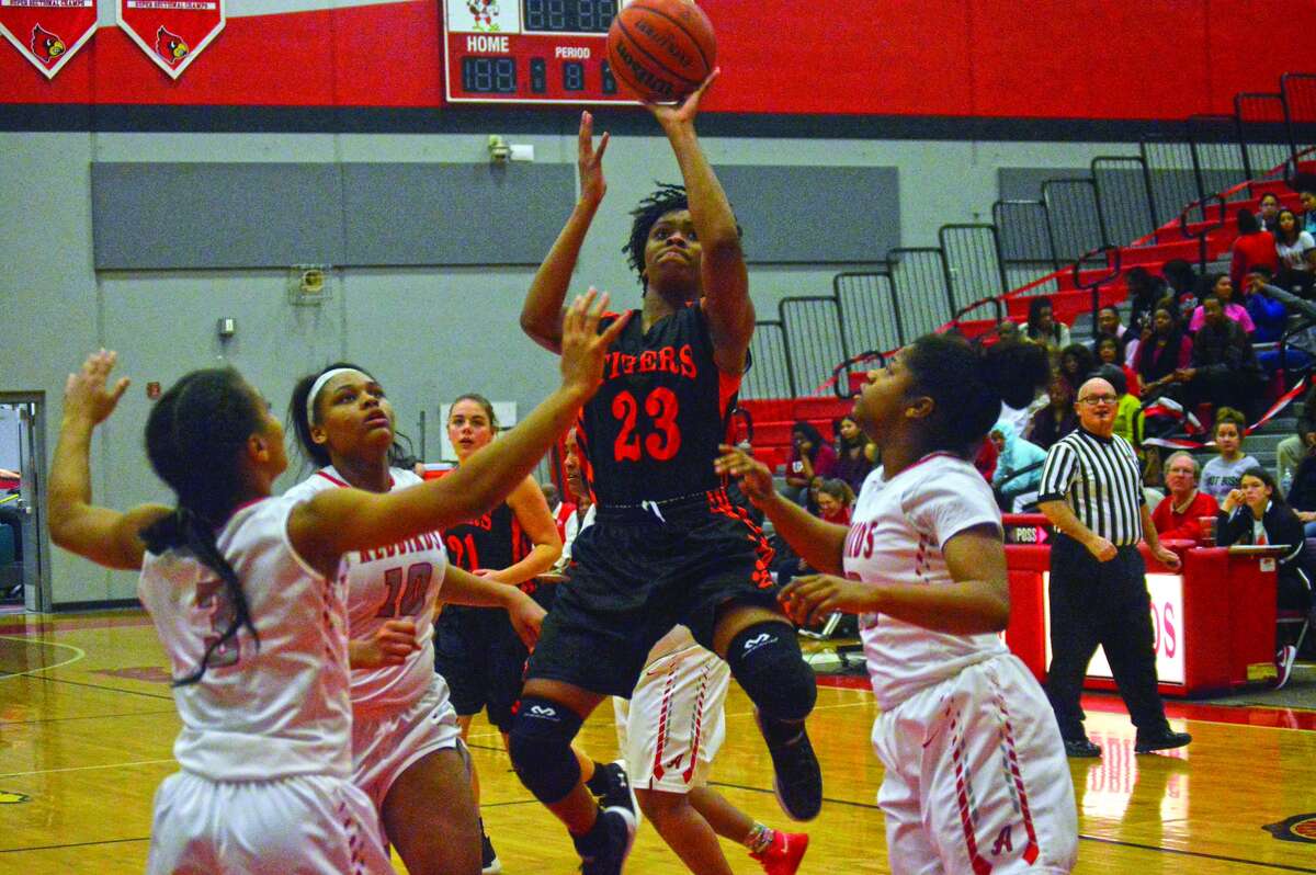 Edwardsville senior Myriah Noodel-Haywood, center, hits a shot in the lane early in the third quarter of Thursday’s Southwestern Conference game at Alton.