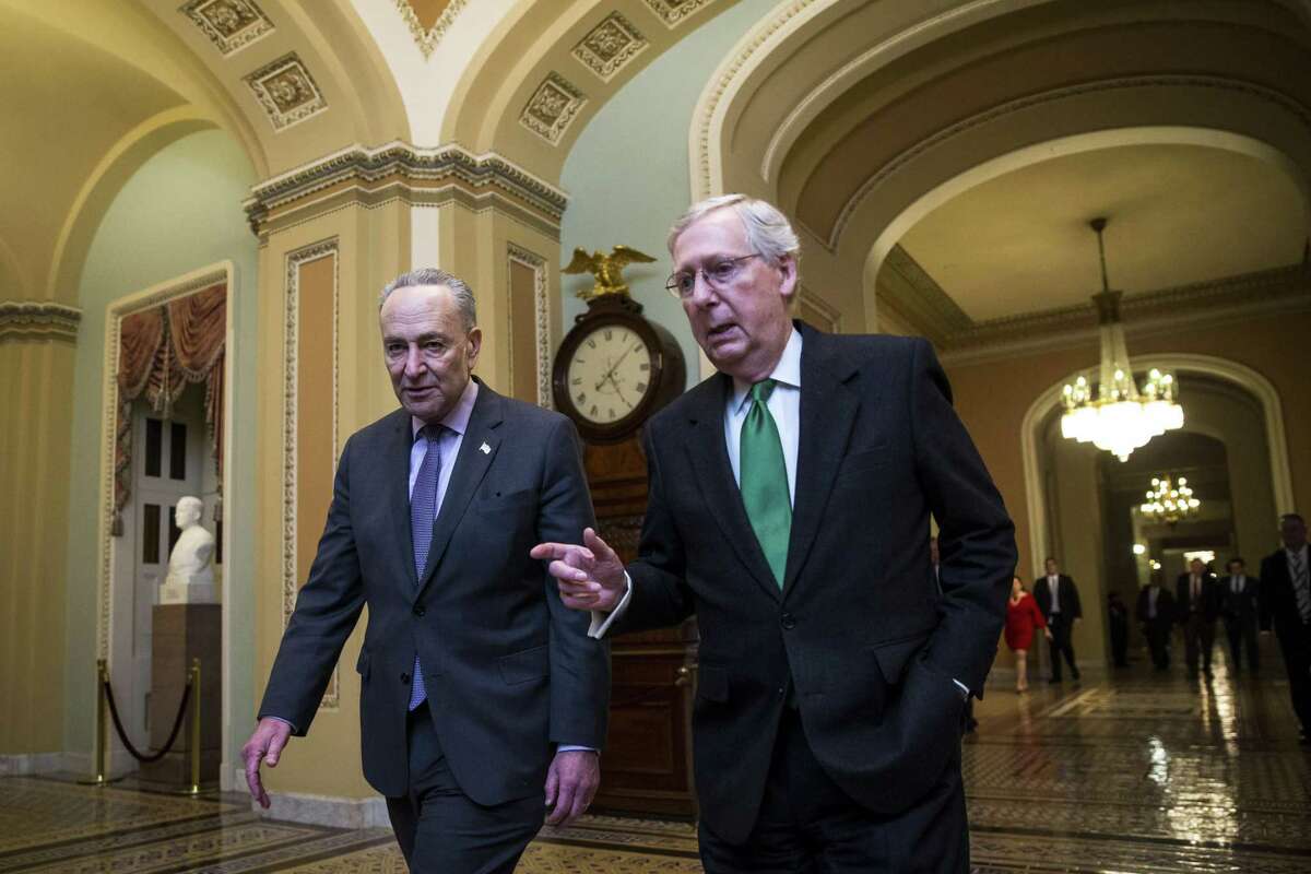 Senate Majority Leader Mitch McConnell (R-Ky.), right, and Senate Minority Leader Chuck Schumer (D-N.Y.) walk to the Senate floor from McConnell's office on Capitol Hill in Washington, Feb. 7, 2018. Senate leaders struck a far-reaching agreement on Wednesday that would raise spending caps on military and domestic spending, and it could help ensure passage of a temporary measure to keep the government open past Thursday. (Al Drago/The New York Times)