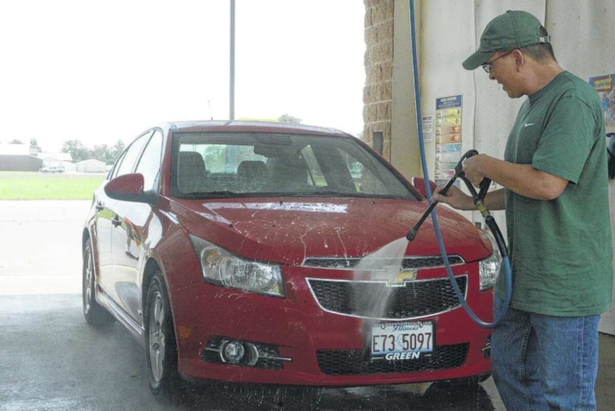 Cory West sprays his Chevy Cruze on a warm Monday afternoon at Quick Lane Car Wash in South Jacksonville.