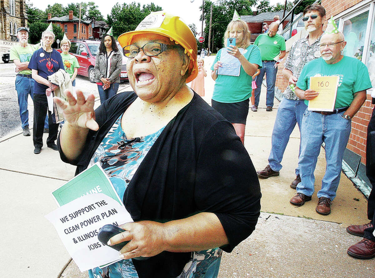 The Rev. Norma Patterson fires up a crowd of about 50 protesters outside of the Alton office on State Sen. Bill Haine on Henry Street in Alton Wednesday as the group gathered to support the Illinois Clean Jobs Bill. The bill, according to supporters, would help create 32,000 new jobs through a variety of means including increasing the share of power used in Illinois from wind and solar sources. After finishing at Haine’s office, the group marched up Henry Street to the office of State Rep. Dan Beiser.