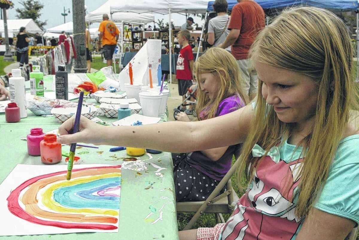 Abby Crays (foreground), 10, and her 7-year-old sister, Ally Crays, paint rainbows Saturday during the Art Fair on the Square. The event featured 30 artists, including potters, painters, photographers and wood carvers.
