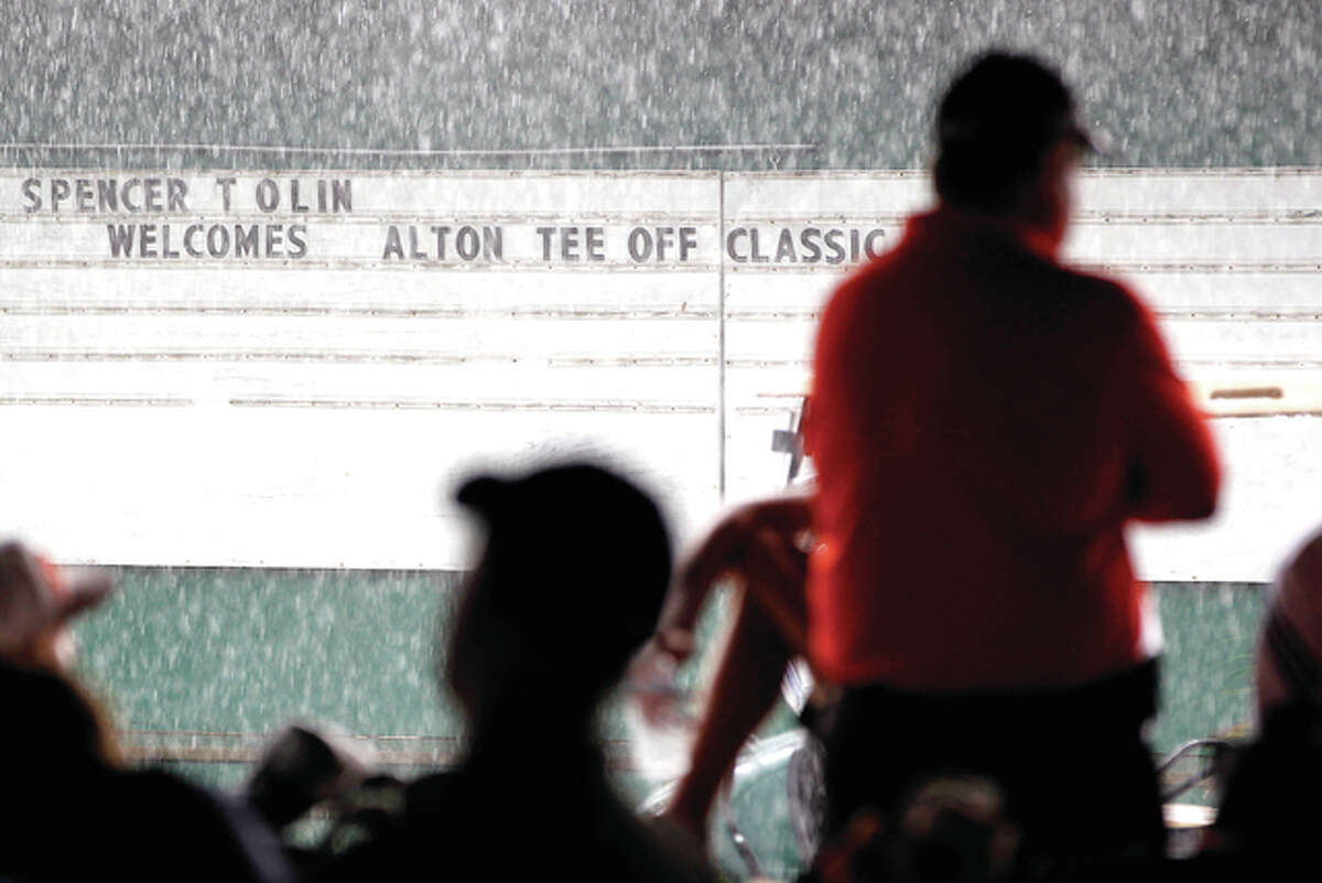 Golfers, coaches and spectators seek shelter and wait out a lengthy rain delay Tuesday during the Alton Tee Off Classic at Spencer T. Olin Golf Course in Alton. The 21-team classic was eventually cancelled. It wiull not be rescheduled.