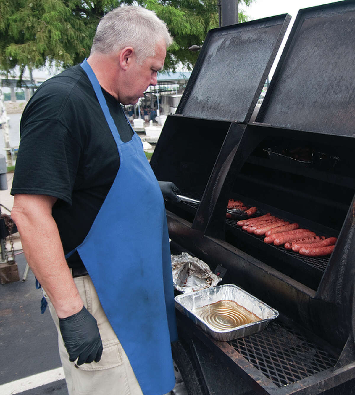 Chemist-by-day Bill Stork, who is a professional BBQ chef and owner of Riverbend-based Black Iron BBQ, enticed people with his brats, pulled pork, brisket and hot dogs Saturday night at the Alton Marina during its free 19th anniversary party.