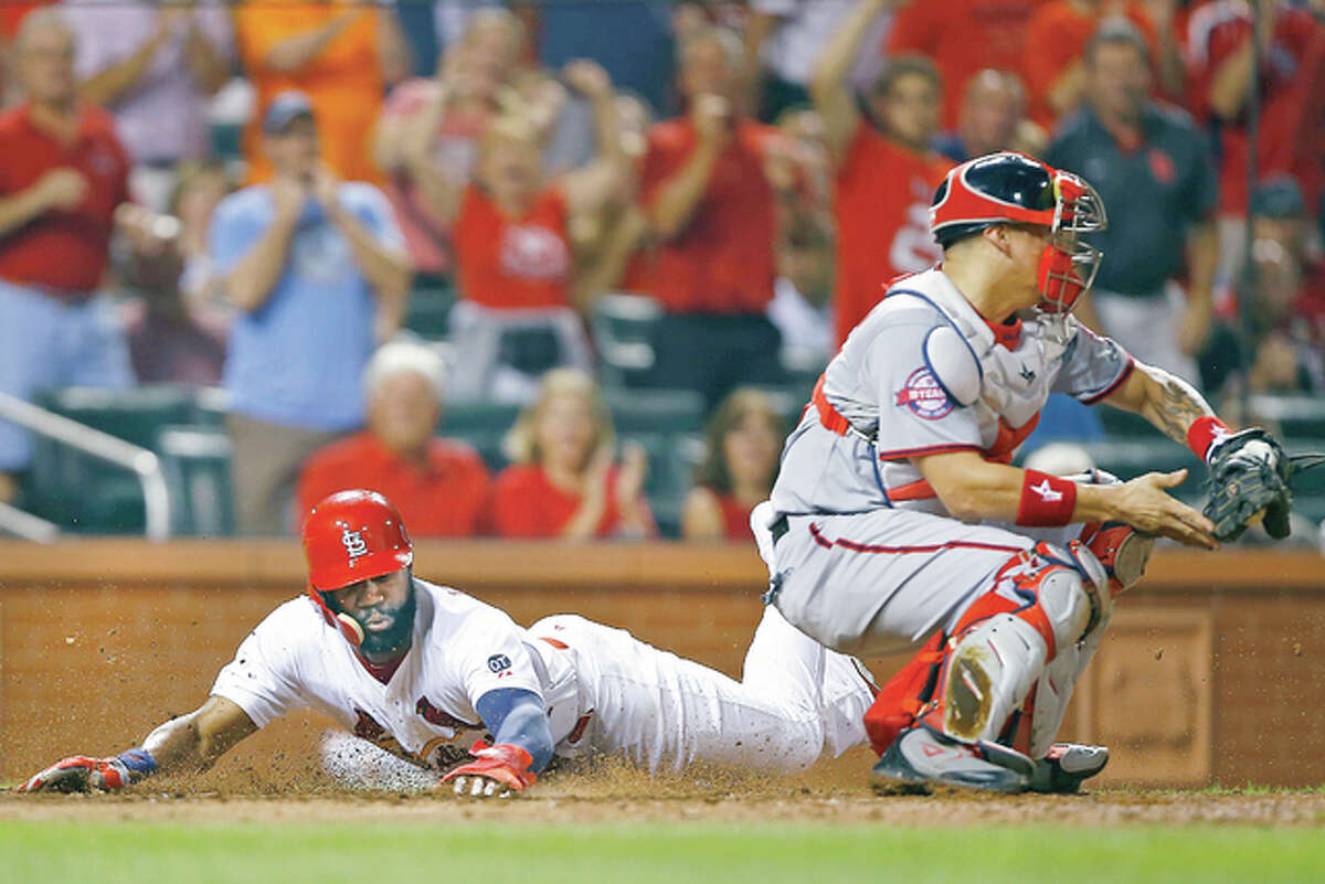 The Cardinals’ Jason Heyward, left, slides in safely ahead of the tag by Washington Nationals catcher Jose Lobaton, on a single by Kolten Wong in the seventh inning Monday at Busch Stadium. The Cardinals won the game 8-5.
