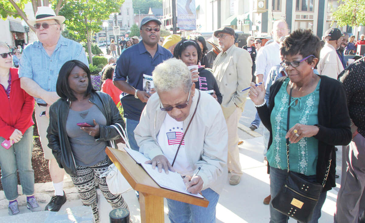 Norma Henderson, of Alton, signed a guest book at the Miles Davis Sculpture Unveiling celebration Saturday in Downtown Alton. Hundreds of people gathered for the ceremony.