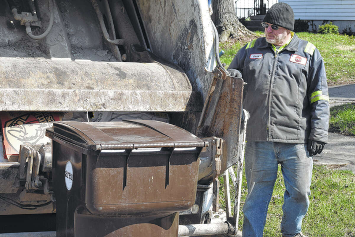 Area Disposal employee Chuck Jennings loads his truck with garbage early Monday.