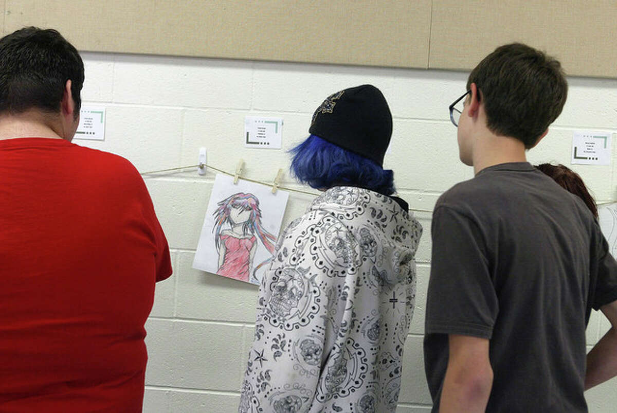 Students from Garrison Alternative School look at artwork Monday in the school caferteria.