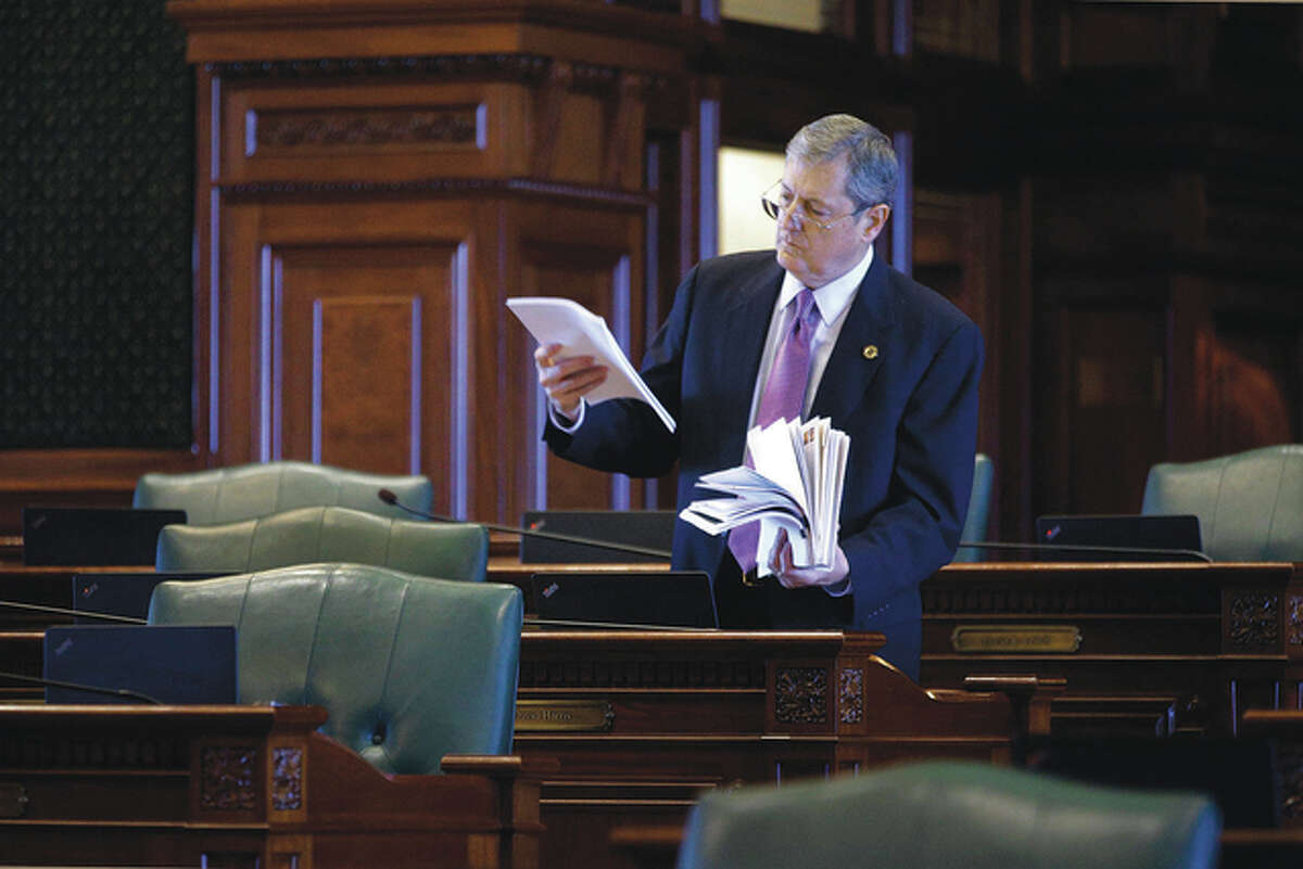 Seth Perlman | AP Rep. David Harris, R-Mount Prospect, reads through legislation while on the House floor just before the beginning of session Thursday. Lawmakers pressed ahead in the waning days of the spring legislative session, a day after House Democrats pushed through a budget proposal that Republicans decried as phony and $7 billion out of whack. Gov. Bruce Rauner has signaled he would veto the bill, but it still must get through the Democrat-controlled Senate.