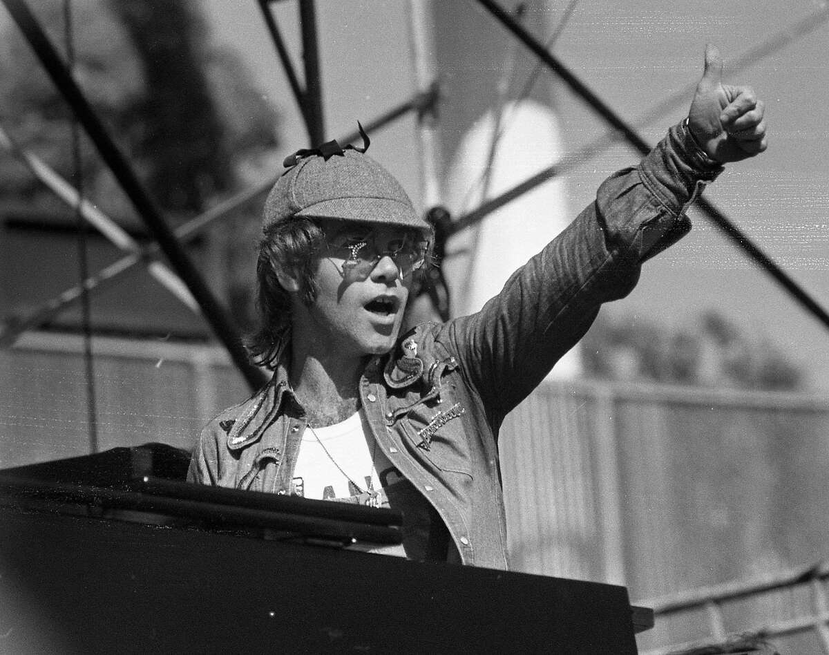 Unscheduled to perform Elton John surprises that audiences by playing piano with both the Doobie Brothers and thee Eagles at the Day on the Green held at the Oakland Coliseum, June 30, 1975