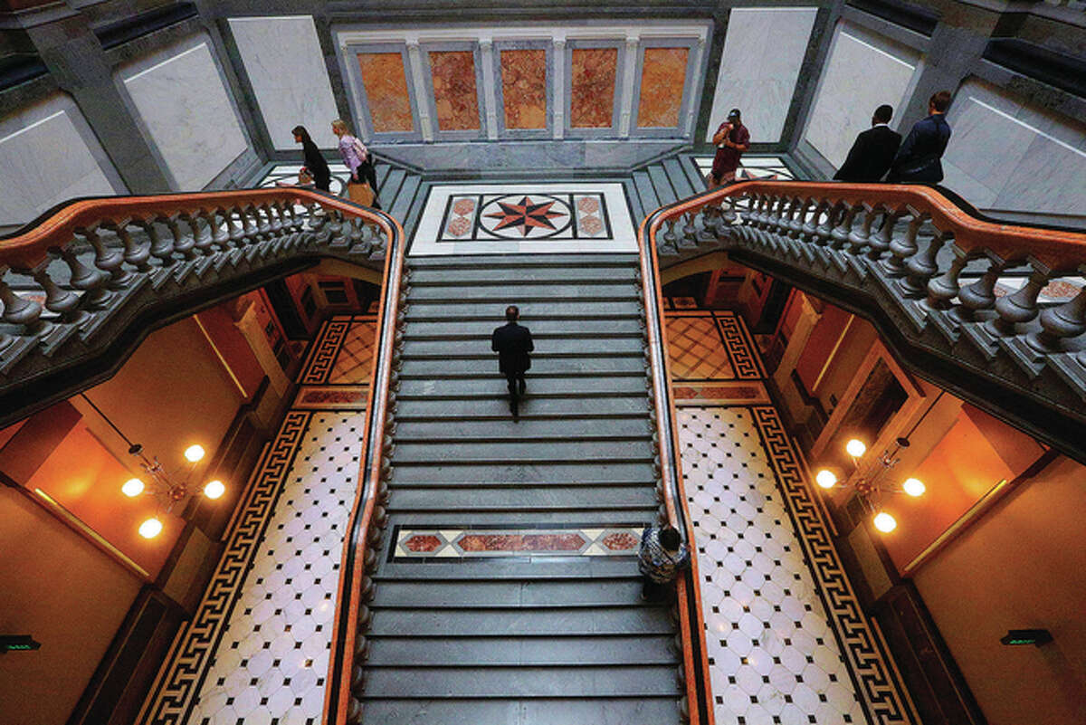 Lobbyists, lawmakers and tourists navigate the stairway to the “brass rail” outside the Senate and House chambers at the state Capitol on Tuesday as lawmakers press ahead in the last day of the spring legislative session. Gov. Bruce Rauner proposed a short-term budget fix Tuesday in a last-ditch effort to give the state some temporary stability during a nearly yearlong spat between the Republican and Democratic lawmakers over a spending plan.