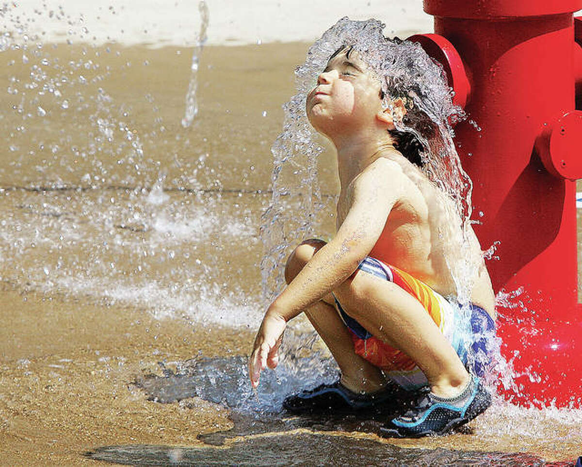 John Badman|The Telegraph Adrian Sova, 4, of Edwardsville, Ill., squated down in front of the replica fire hydrant in the Hartford, Ill., Splashpark to take the plunge on one of the last days of summer vacation Monday August 17, 2015. Most Southwestern Illinois school students return to classes this week, many on Wednesday.