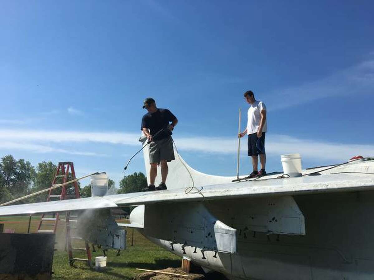 Volunteers with the Flight Deck Veterans Group and the community wash morethan 25 years of dirt and debris off the aircraft.