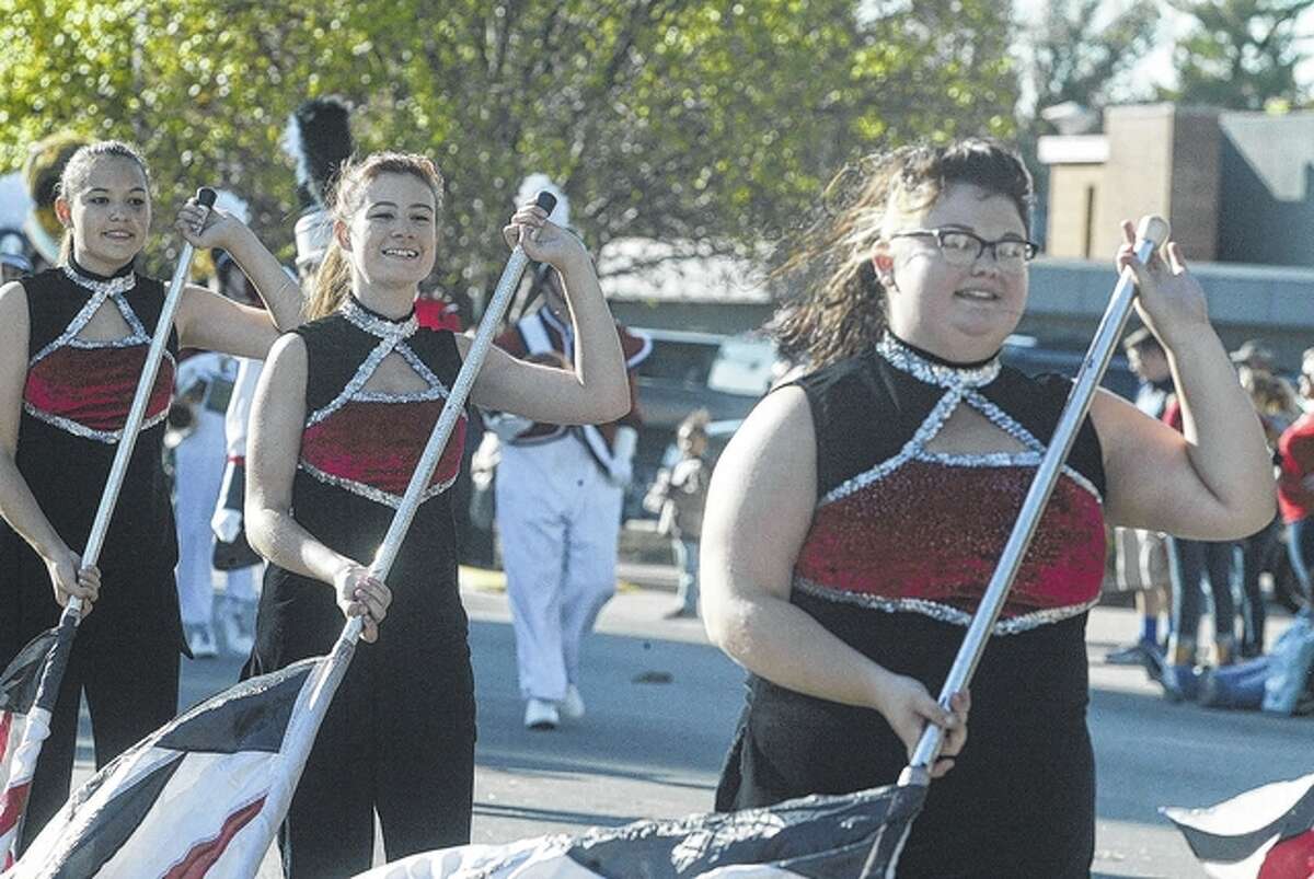 Members of the Jacksonville High School Marching Crimsons flag team perform in the Jacksonville Homecoming Parade Friday.