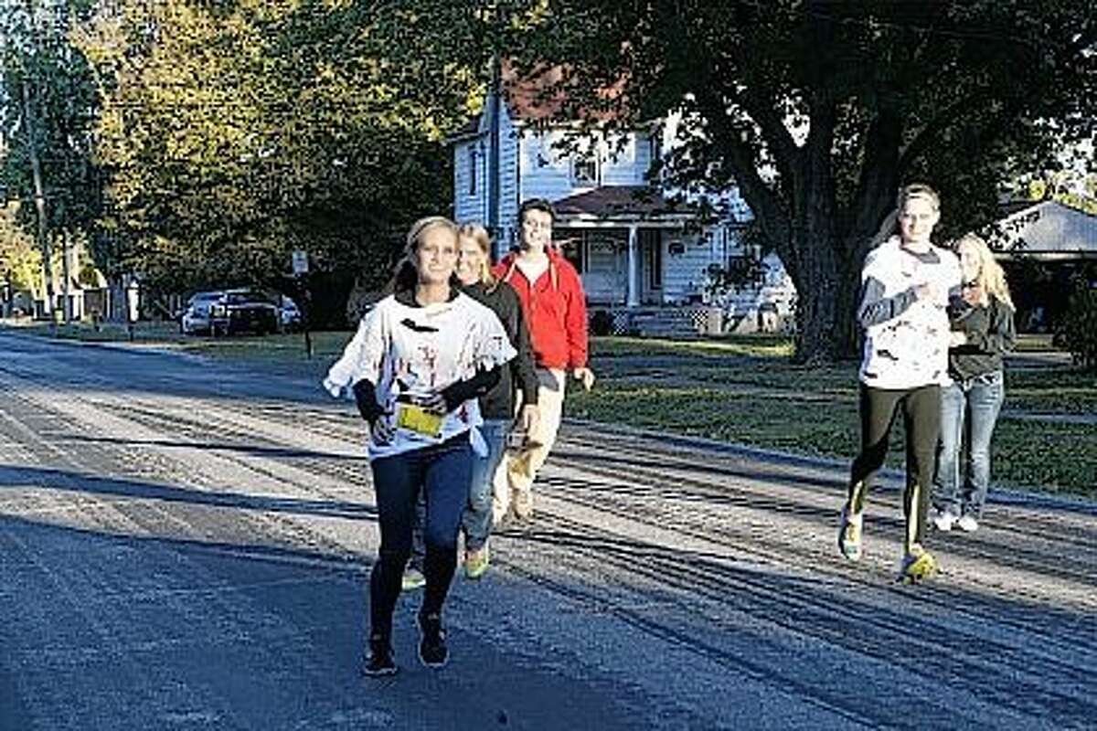 Runners try to avoid getting tagged by “zombies” Saturday on West Independence Avenue during the second annual WJIL-WJVO Zombie 5K. Proceeds go to Protecting Animal Welfare Society, better known as PAWS.