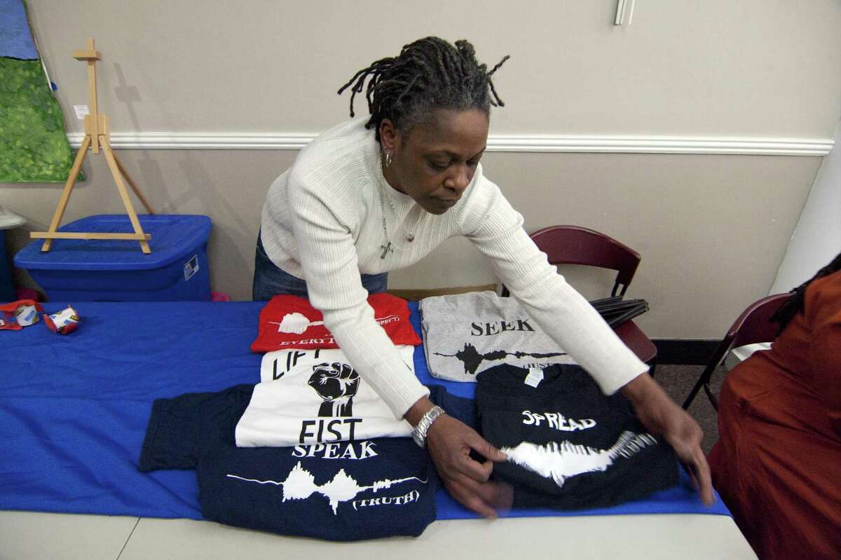 Gale Clay, of Waveformz Visual Speech, puts out T-shirts she has created to sell during the Margaret E. Morton Goverment Center's First Annual Bridgeport "Living Legends" Recognition Ceremony as part of the celebration of Black History Month in Bridgeport, Conn., on Thursday Feb. 8, 2018. Mayor Joe Ganim and the City of Bridgeport honored 12 unsung African American heroes from the Bridgeport community for Black History Month. Actor and activist Tenisi Davis gave remarks. Davis, a Bridgeport native, appears on the CBS show Blue Bloods. Spoken Word and musical selections were performed by students at the University of Bridgeport's Sophisticated Love of the Artistic Mind Club (SLAM). Local artisans Nanette Malone, Gale Clay and others sold their jewelry, crafts and artwork.