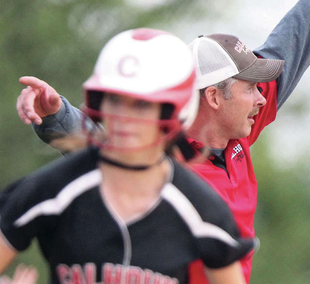 Calhoun coach Matt Baalman (right) sends one runner home while holding another at second base during a 2015 sectional victory in Mount Sterling. After winning back-to-back state titles in 2015-16, Calhoun added a Class 1A state runner-up trophy in 2017 to earn Baalman honors as Telegraph Small-Schools Softball Coach of the Year.