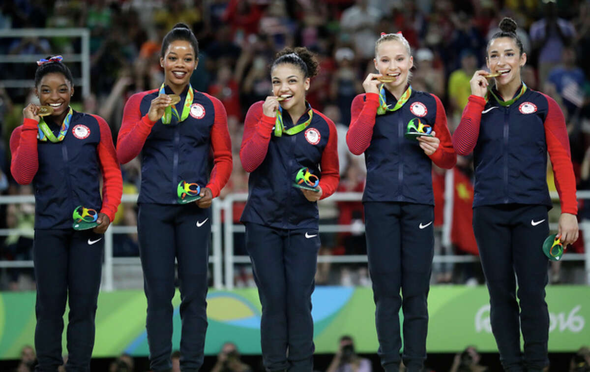 U.S. gymnasts, left to right, Simone Biles, Gabrielle Douglas, Lauren Hernandez, Madison Kocian and Aly Raisman hold their gold medals during the medal ceremony for the artistic gymnastics women's team at the 2016 Summer Olympics in Rio de Janeiro, Brazil, Tuesday, Aug. 9, 2016. (AP Photo/Julio Cortez)