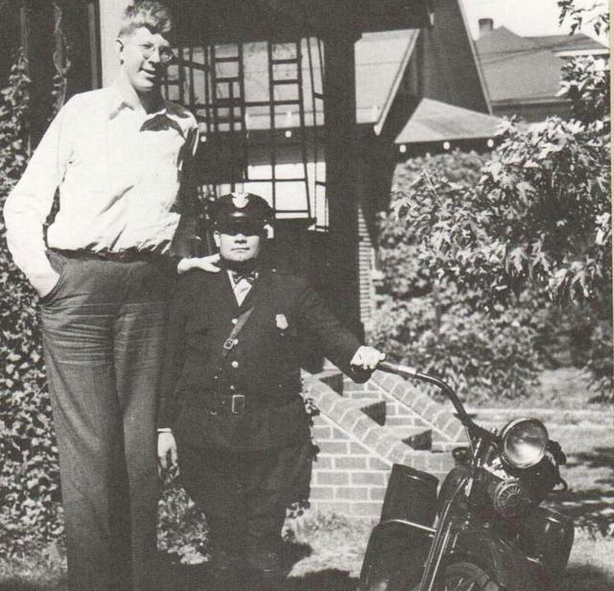 Robert Wadlow was never too busy to pose for a photograph with a friend. Here, Alton Patrolman Louis Waller and Robert show off the new motorcycle. They are standing outside Wadlow’s home on Brown Street in Upper Alton.