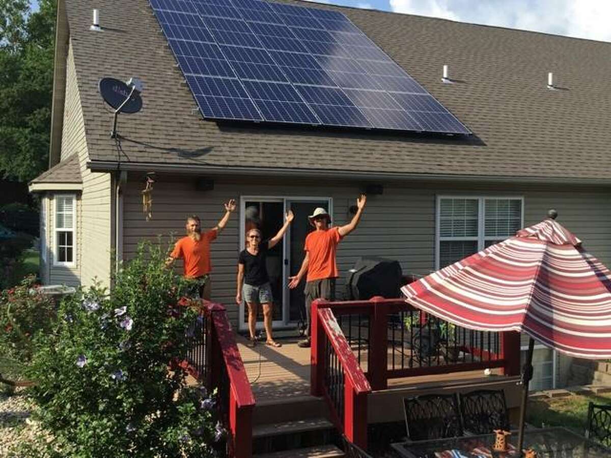 Julie Zimmerman, center, celebrates the look and value of her home’s new 5.7 KW Solarize Madison County/Glen Carbon solar array.
