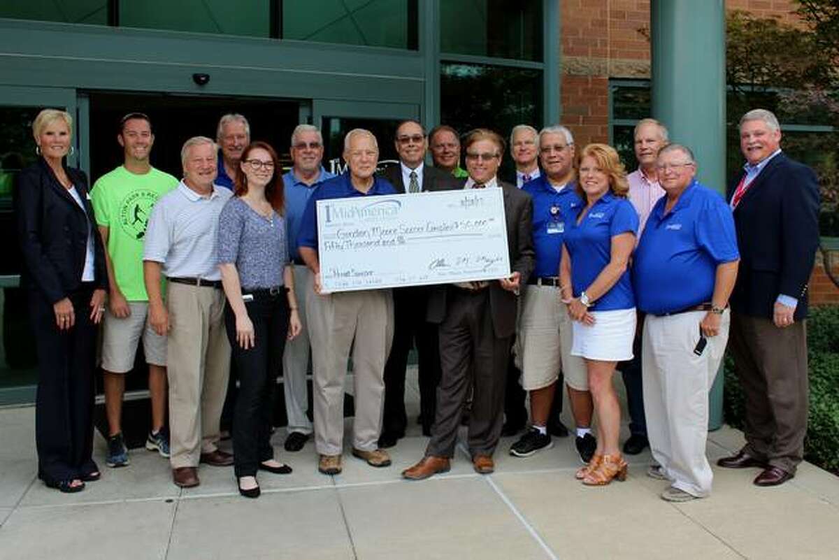Alton Mayor Brant Walker and members of the Gordon Moore Park Restoration Committee accept a $50,000 donation from 1st Mid-America Credit Union board members and senior officials. The donation will assist with the park’s current restoration and includes the credit union acquiring naming rights to the park’s Soccer Complex. The Park Restoration Project is currently in process with more details at www.prideincorporated.org.