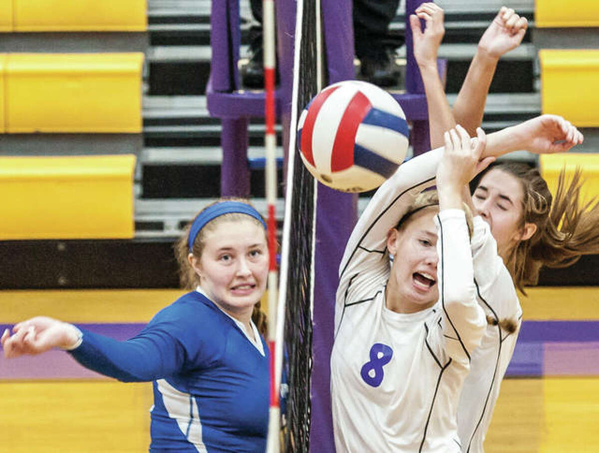 Marquette Catholic’s Regina Guehlstorf (left) wins a battle at the net Wednesday night against Civic Memorial’s Sydney Henke (8) and Savannah Roth. Marquette won that three-set match at CM, but dropped a three-setter Thursday night to Greenville in Alton, despite 17 kills from Guehlstorf.