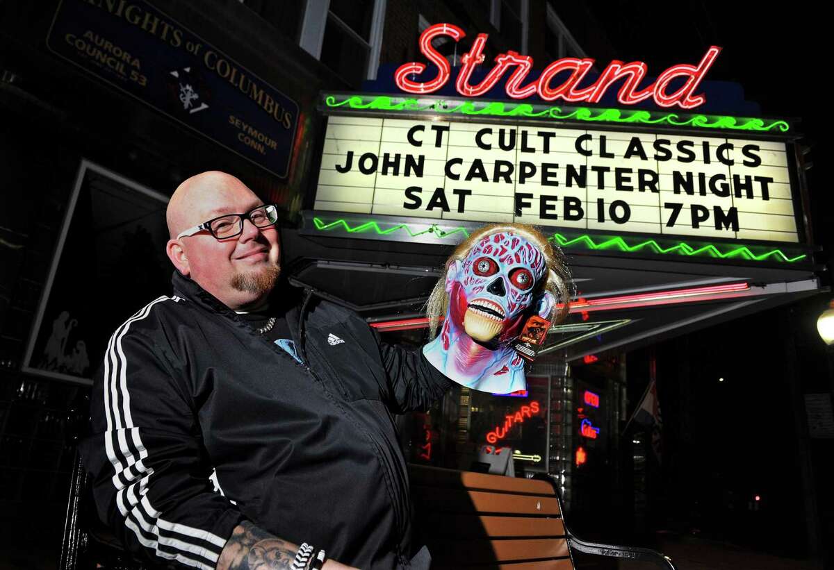 Horror film fan Larry Dwyer poses by the marquis of the Strand movie theater in SeymourTuesday.