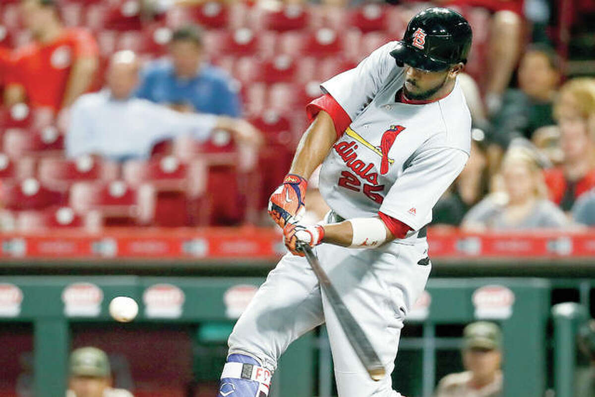 The Cardinals’ Dexter Fowler hits an RBI double to drive in Kolten Wong with the go-ahead run off Cincinnati Reds starting pitcher Tim Adleman in the 10th inning of Tuesday night’s game in Cincinnati. The Cardinals won 8-7.