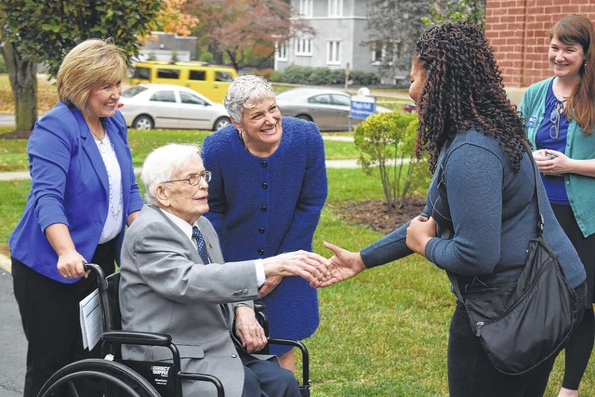 Pam Birdsell and Illinois College President Barbara Farley stand behind former Congressman Paul Findley as he shakes the hand of Illinois College archivist Porsha Butler outside of Whipple Hall on Thursday.