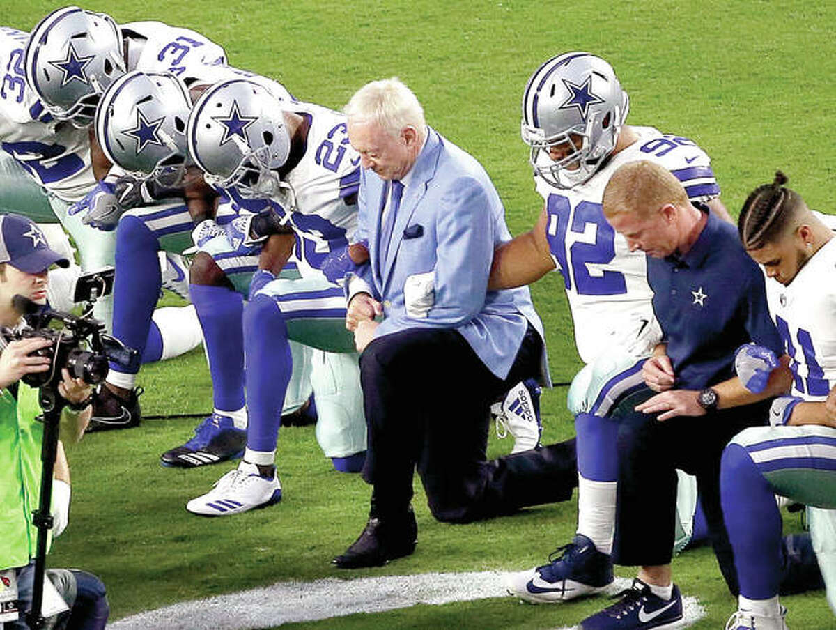 The Dallas Cowboys, led by owner Jerry Jones, center, take a knee prior to the national anthem prior to Monday night’s game against the Arizona Cardinals, in Glendale, Ariz.