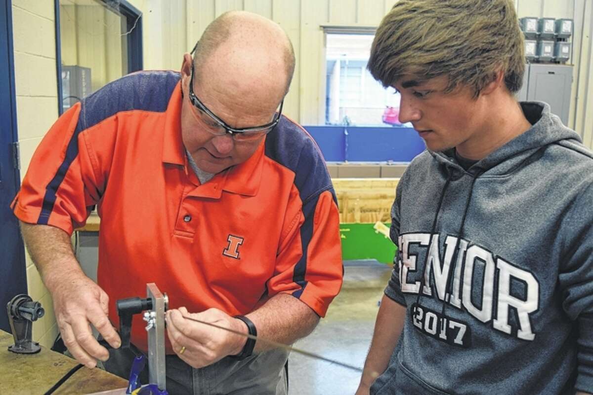 Teacher Kevin Fraser helps Dylan Malin, 17, of White Hall cut frets for his guitar.