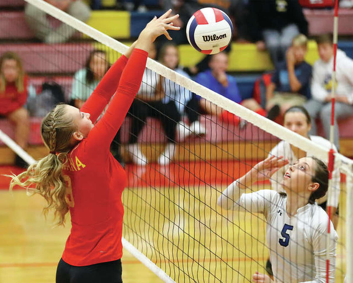 Roxana’s Abi Stahlhut (left) puts down a block over Greenville’s Ally Cantrill (5) during Tuesday’s regional semifinal in Roxana.