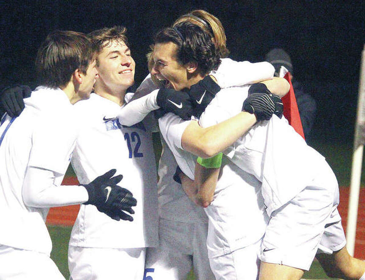 Marquette’s Noah Fahnestock celebrates with teammates Isaac Hendrickson and Nick LaFata after scoring a penalty kick in the second half of Saturday night’s Class 1A state title game.
