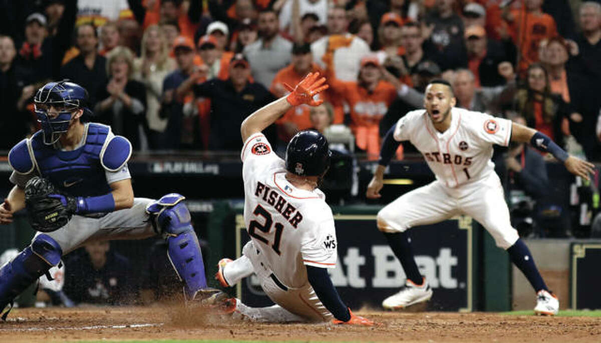 The Astros’ Derek Fisher (center) scores during the 10th inning of Game 5 of the World Series against the Los Angeles Dodgers on Monday night in Houston. The Astros lead the series 3-2.