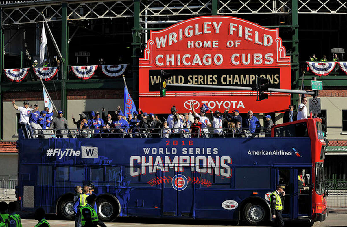 Paul Beaty | AP A bus carrying Chicago Cubs players, family and friends passes Wrigley Field during a parade honoring the World Series champion baseball team in Chicago. The Cubs first World Series title since 1908 is the runaway winner for top Illinois story and also top sports story of 2016.