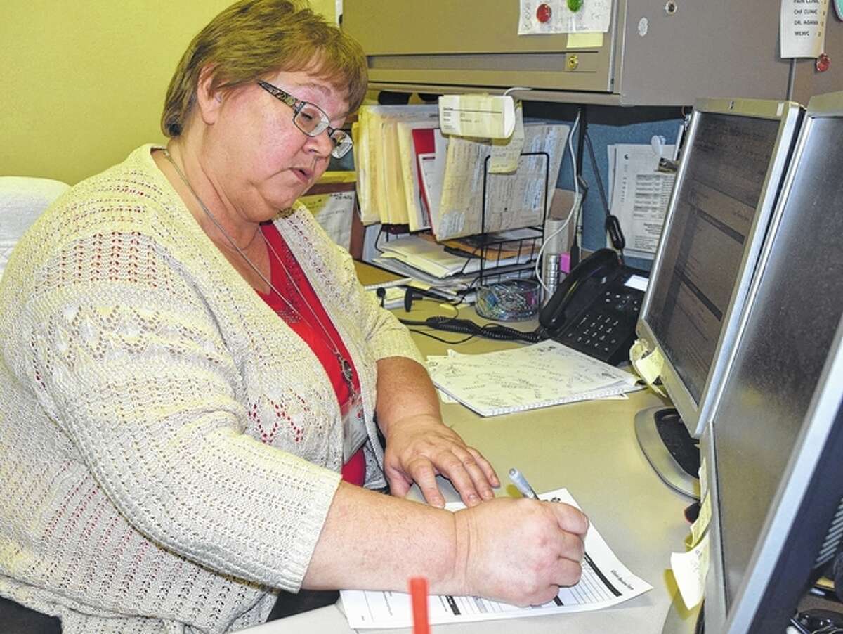 Rosemary Hopkins, a reimbursement specialist at Passavant Area Hospital, fills out insurance forms Thursday.