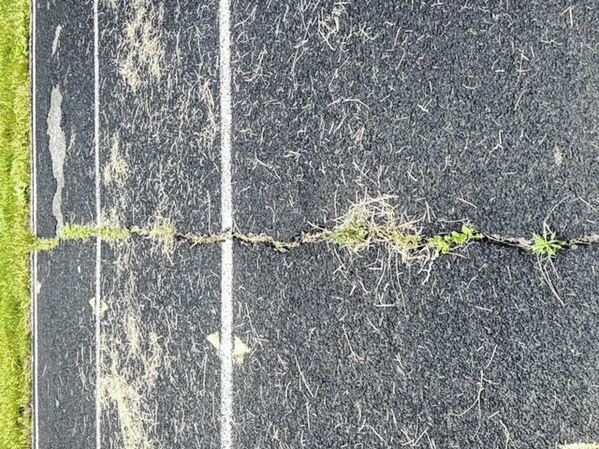Cracks such as this one can be found throughout Carrollton High School’s track, as well as large patches of track with no surface coating at all.