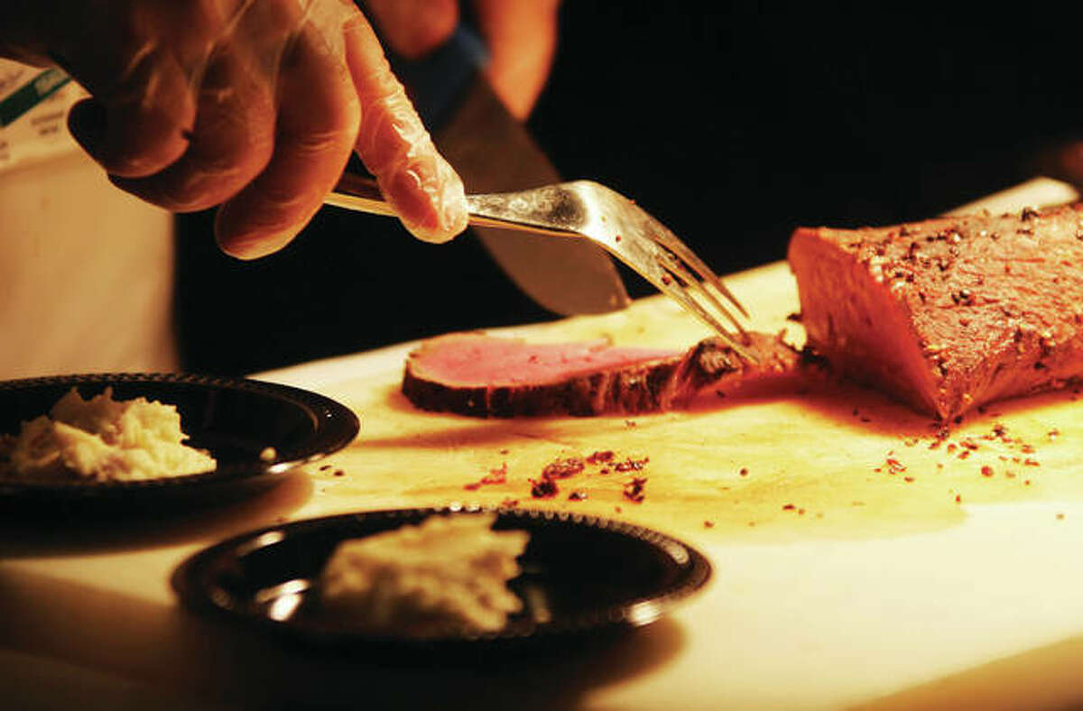 Pepper tenderloin from Journey, a restaurant at the Argosy Casino, is cut by a server at Taste of Downtown, an annual fundraiser for Alton Main Street, held Thursday in the Music Hall at the casino.