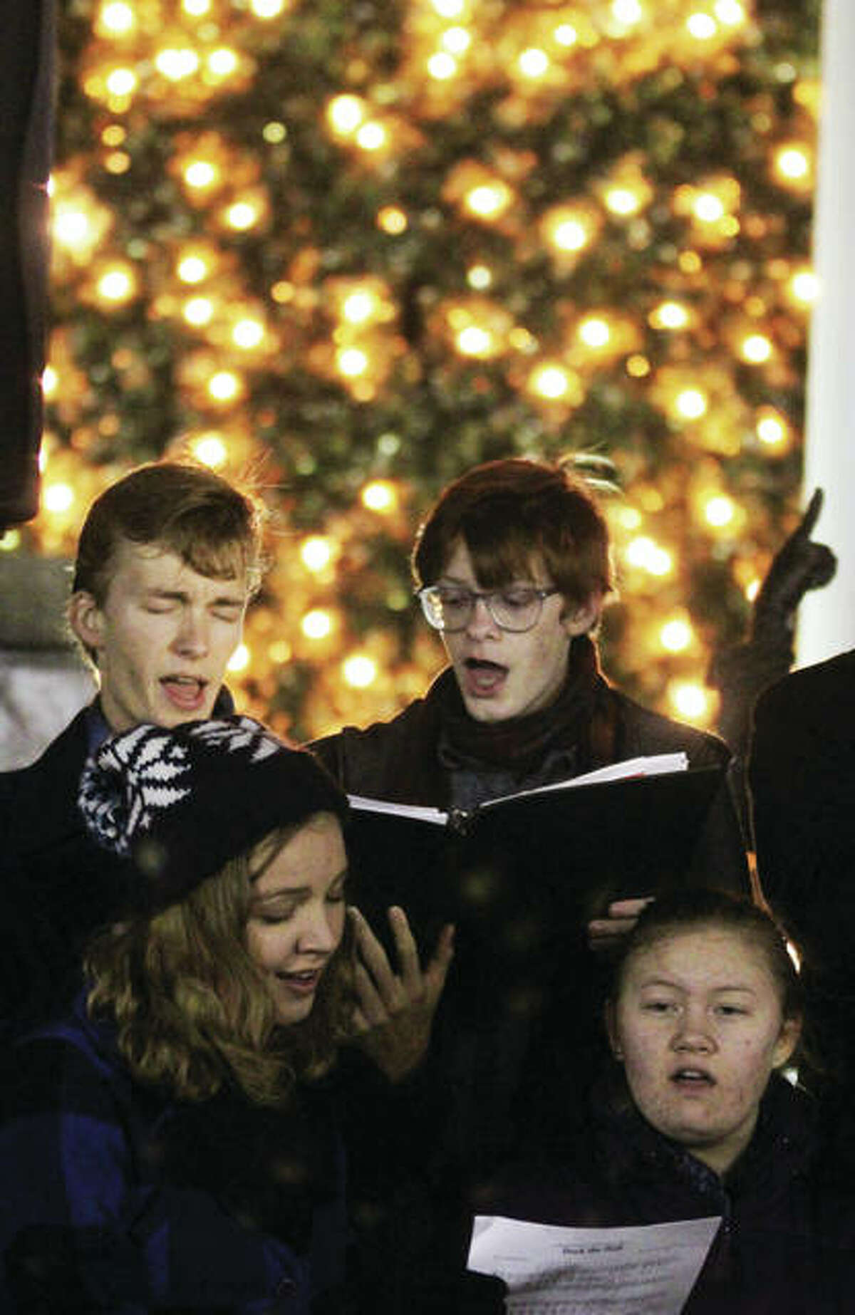 Alton High School Chamber Singers members Kevin Neace, clockwise from top left, Austin Turnbull, Dominique Reinier and Audrey Neace perform Christmas carols during the 23rd annual Christmas Tree Lighting in Lincoln-Douglas Square in downtown Alton. The ceremony drew about 250 people, and is sponsored by Alton Main Street.