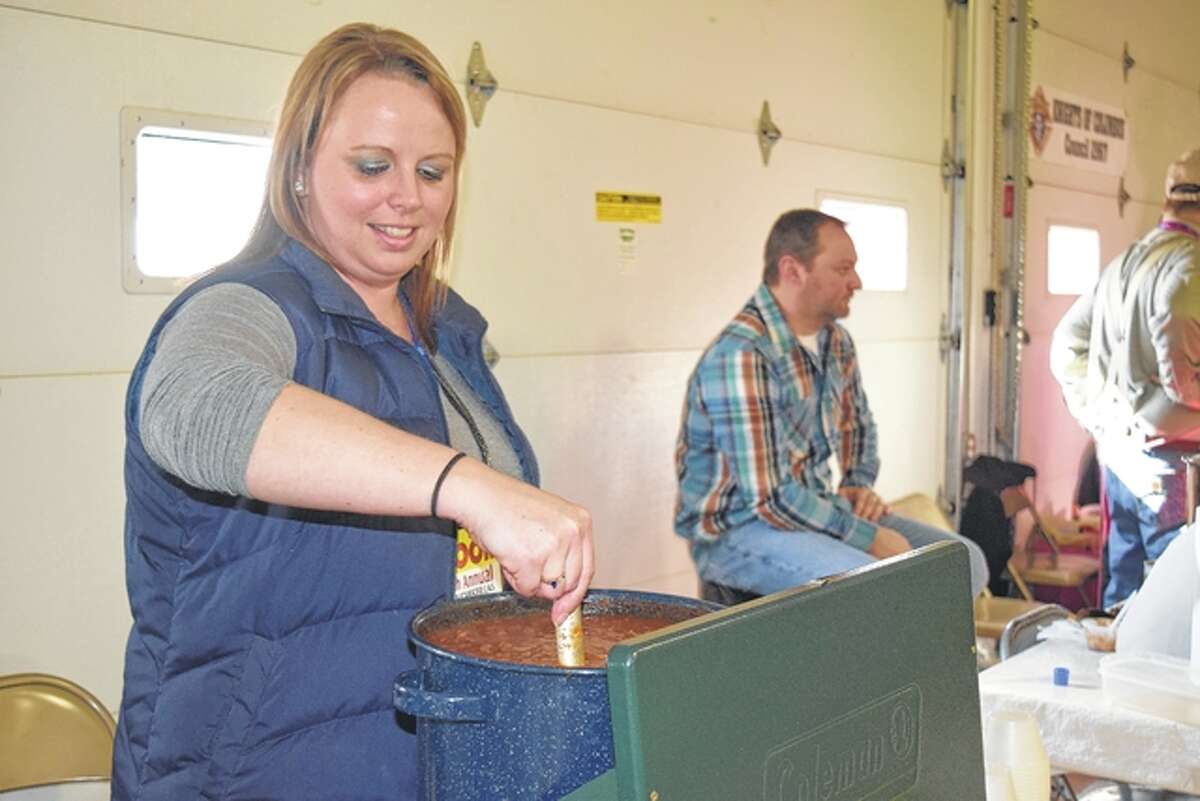 Nichole Mason of Winchester, cooking for Farmers State Bank of Winchester, stirs some chili in preparation for the beginning of the Winchester Chili Cook-off and Salsa Contest on Saturday.