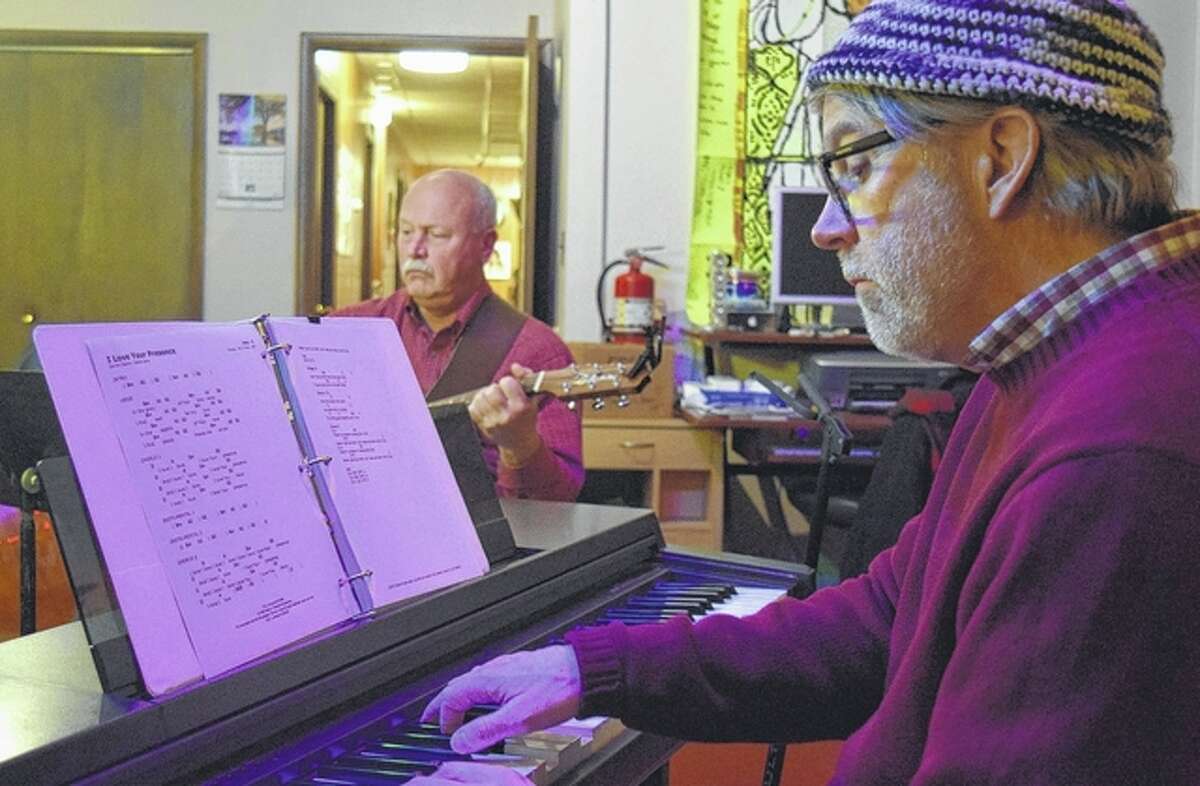Jeff Davidsmeyer plays the piano Thursday night during a Christian music worship circle event at the Christian Performing Arts Productions studio on the west side of Jacksonville’s downtown square. In the background is John Potter.