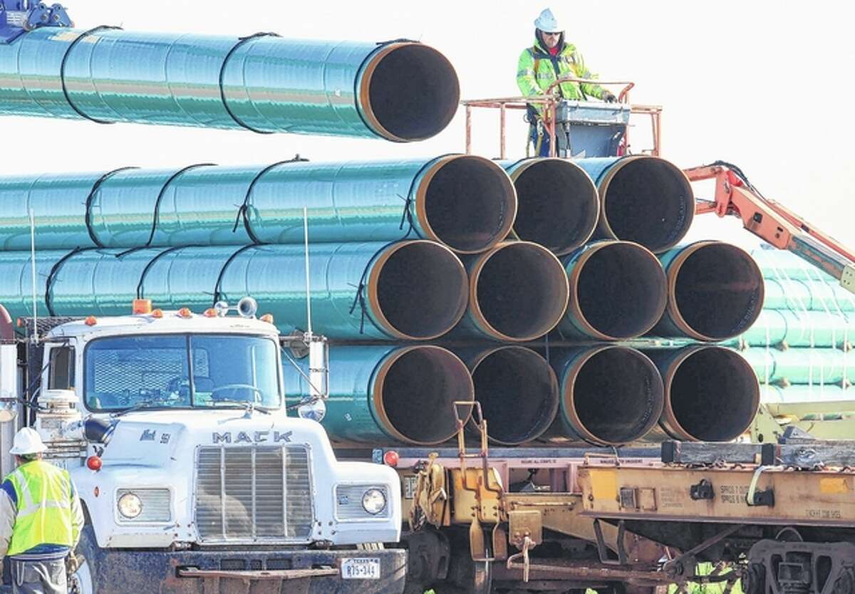 Nati Harnik | AP Workers unload pipes in 2015 for the Dakota Access oil pipeline, which will stretch from the Bakken oil fields in North Dakota to Illinois, including a large part of Morgan County and west-central Illinois. The Dakota Access project, which is mostly completed, has created about 12,000 construction jobs, according to project leader Energy Transfer Partners LP. Most of those jobs are over, however.