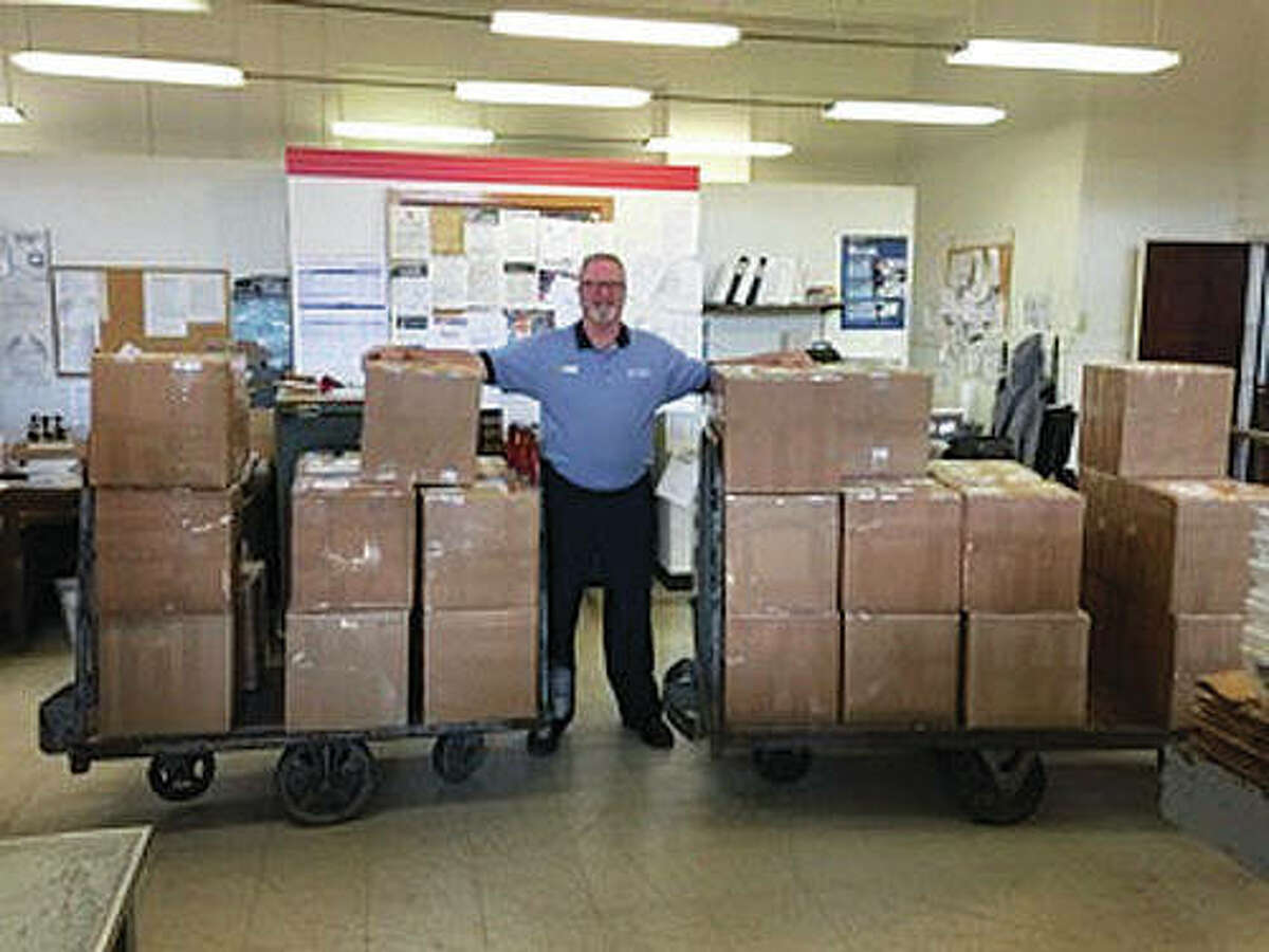 U.S. Army veteran of 16 years and current U.S. Postal Service representative Mark Bowen stands guard over the Christmas boxes that were ready to ship — and since have been shipped — to current Macoupin County military members serving overseas. The “Christmas for a Soldier” campaign is a joint effort between the Macoupin Military Support Group and Carlinville’s Shop Local First organization.